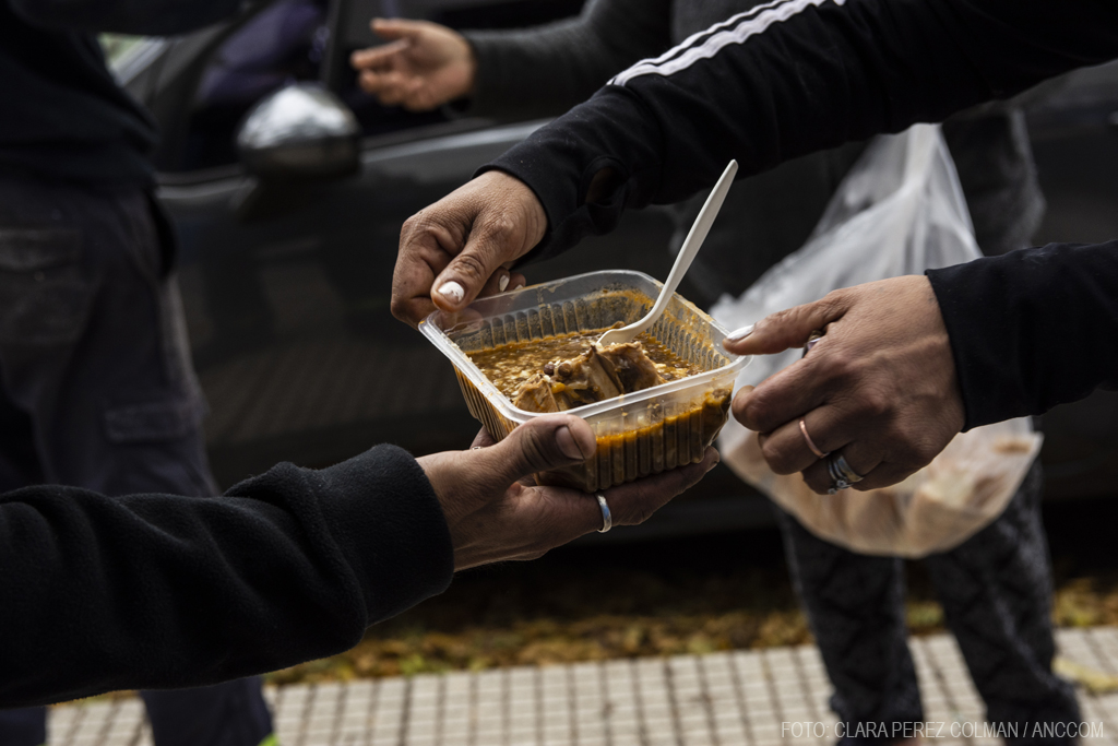 Voluntarios repartiendo comida caliente en la calle